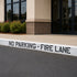 No parking fire lane sign on a street in front of a building.