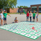 Children playing on a large number grid on a school playground.
