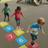 Children playing hopscotch on a playground with colorful squares.