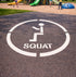 Squat symbol on a playground surface with children playing in the background