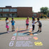 Children playing a game on a school playground with numbered steps on the ground.
