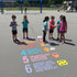 Children standing around a series of numbers and problem-solving steps on a playground surface.