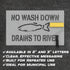 Sign with 'No Wash Down Drains to River' text and fish icon on a dark background