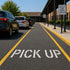 Pick Up Stencil applied to the parking lot of a elementary school pick up line.
