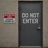 Door with 'Do Not Enter' sign and nearby 'Restricted Area' sign on a brick wall.