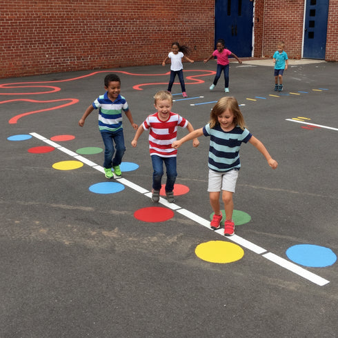 Children playing hopscotch on a school playground with colorful squares.