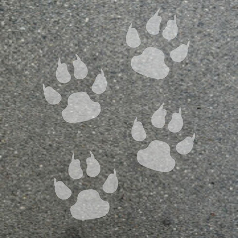 White paw prints stenciled onto a gray asphalt surface