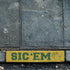 brick paver stenciled with the Sic 'Em Curb Painting Stencil.