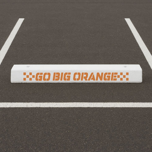white parking bumper stenciled with the Go Big Orange Curb Painting Stencil