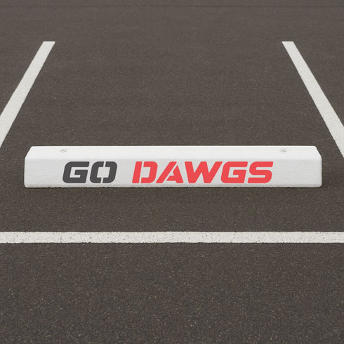 White parking bumper with 'GO DAWGS' stenciled onto the parking space.