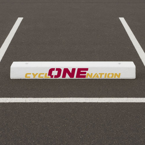 White curb stop with 'CYCLONE NATION' text stenciled onto it.