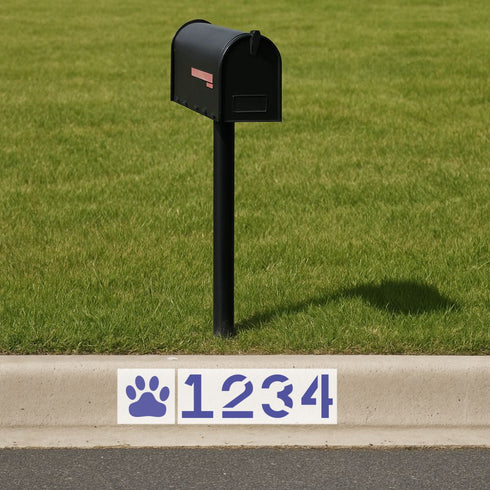 Black mailbox on a grassy area with a street address sign featuring wildcat paw prints and numbers.