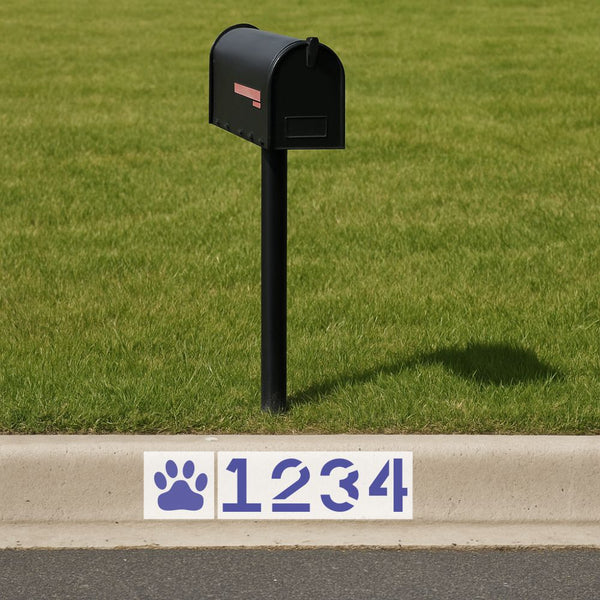 Black mailbox on a grassy area with a street address sign featuring wildcat paw prints and numbers.