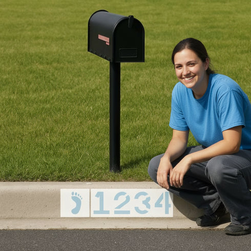 Woman kneeling next to a mailbox with a house number sign on a grassy background
