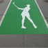 Female Golfer painted onto a high school parking space that has been painted green.