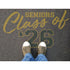 Person standing on pavement that has been stenciled with 'Seniors Class of '26' text.