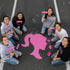 Group of people painting a pink silhouette on the ground