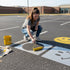 Smiley Face stenciled on pavement with matching parking space stencil.