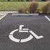 Handicap Parking Lot Stencil applied to a parking lot with white paint.