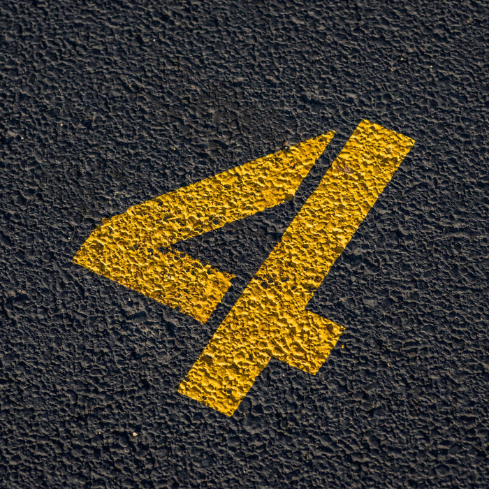 Parking lot number stencil applied to a parking lot