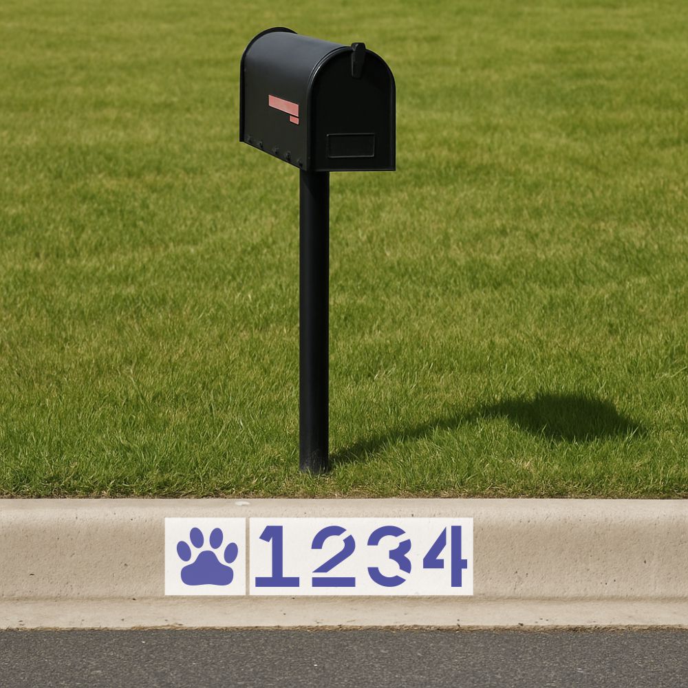 Black mailbox on a grassy area with a street address sign featuring wildcat paw prints and numbers. 