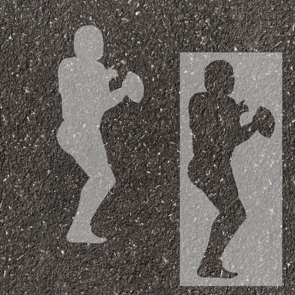 Football quarterback silhouette stenciled on pavement with matching stencil.